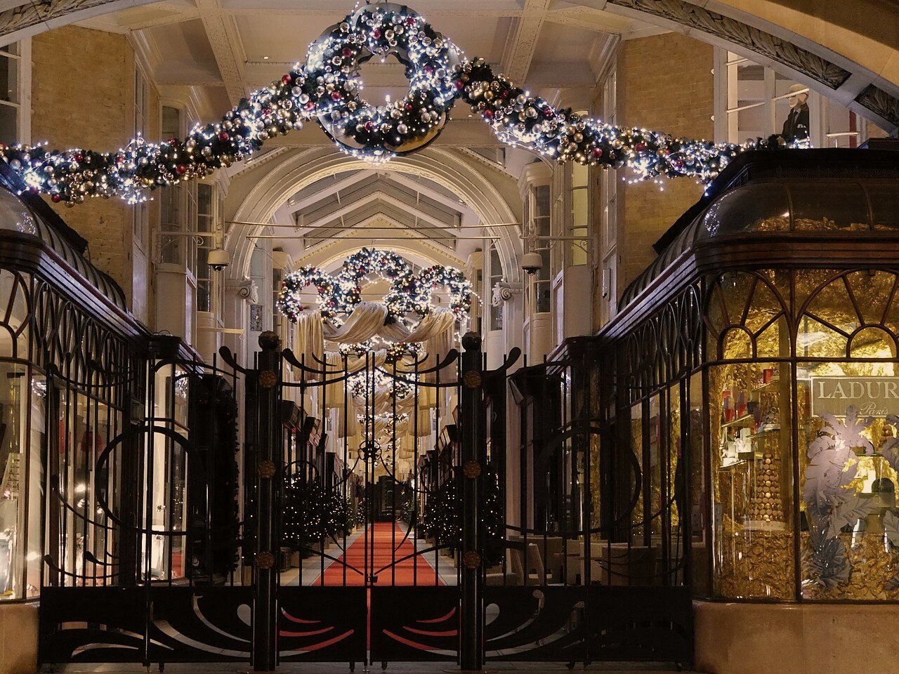 The wrought-iron gates and red carpet of Burlington Arcade — Harrods — P5 Chauffeurs