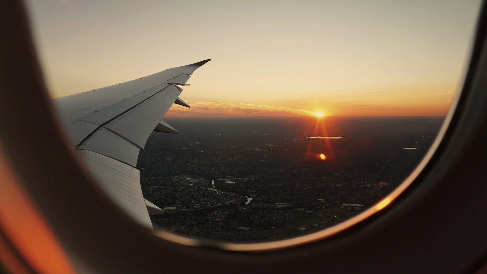 Sunset over the wing from a cabin window — every P5 airport transfer is flight-tracked, so delays are our problem, not yours